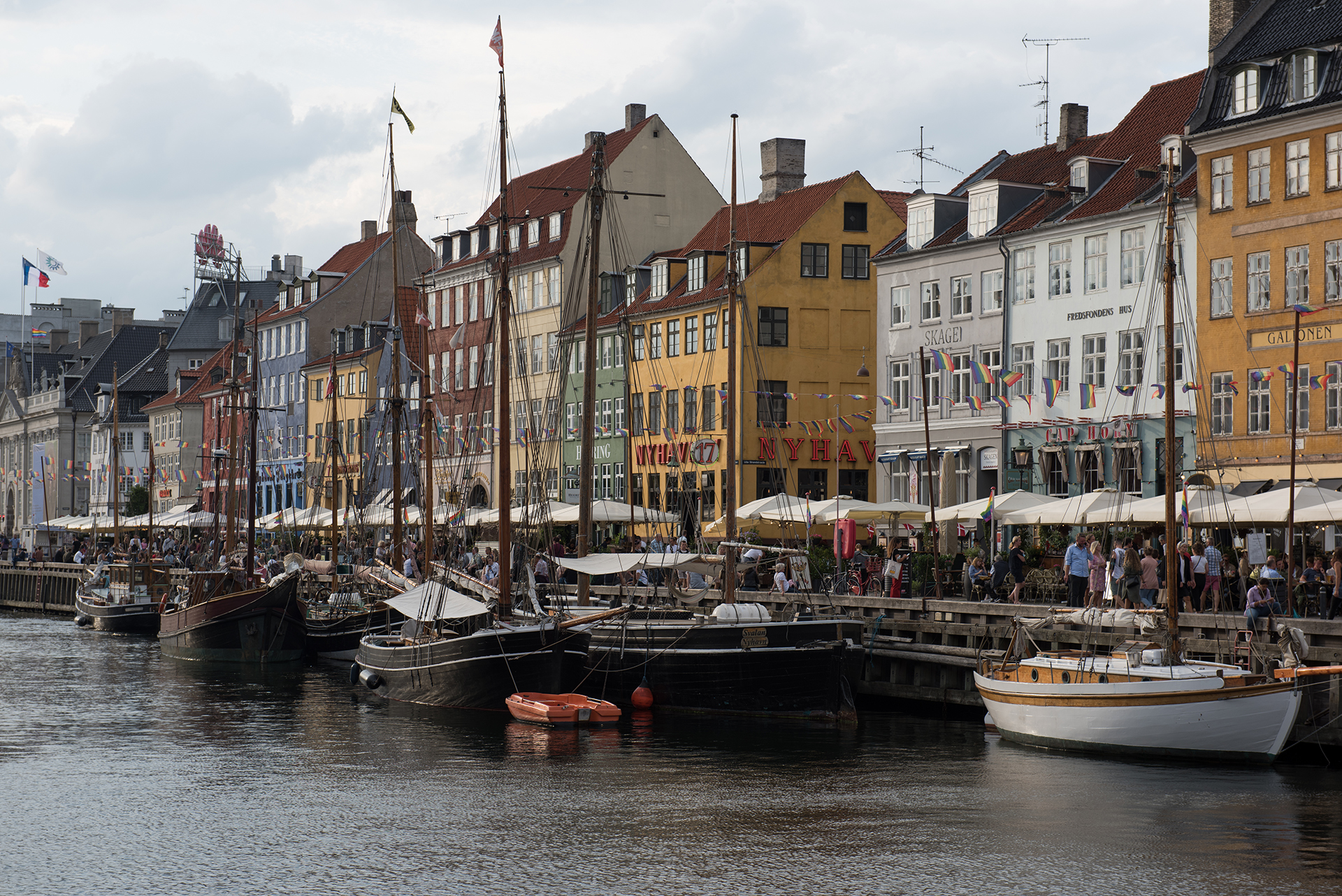 Dania, Kopenhaga - kolorowe zabytkowe kamienice i drewniane jachty nad kanałem Nyhavn.